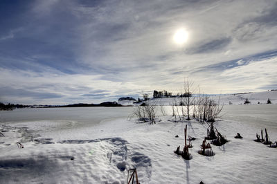 Scenic view of snow covered field against sky