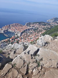 High angle view of townscape by sea against sky