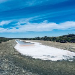 Scenic view of salt pond against blue sky