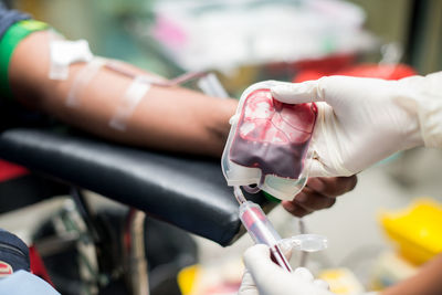 Cropped hands of doctor holding blood bag in hospital