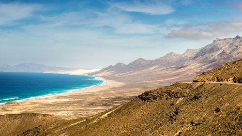 Scenic view of sea and mountains against sky