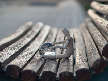 Close-up of human figurine with crystal ball on wooden chair