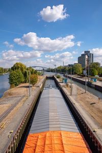 Bridge over river in city against sky