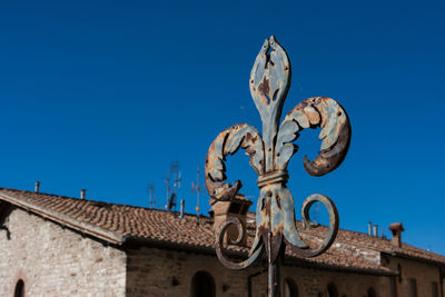 Low angle view of statue against building against clear blue sky