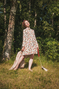 Smiling young woman in tree trunk in forest