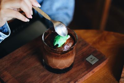 Close-up of hand holding ice cream on table