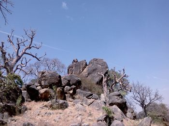 Rock formations on landscape against blue sky