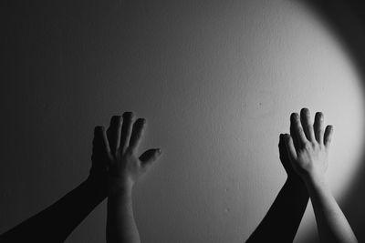 Close-up of hand touching shadow on wall