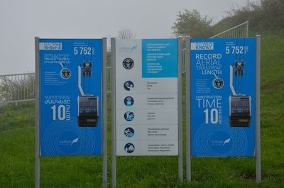 Close-up of information sign against blue sky