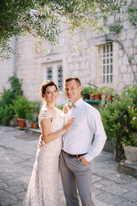 Portrait of smiling couple standing against building