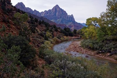 Scenic view of river amidst mountains against sky