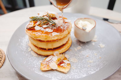 Close-up of honey pouring on pancake in plate