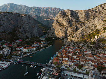 River flowing beetween rocks and mountains with a historical old city