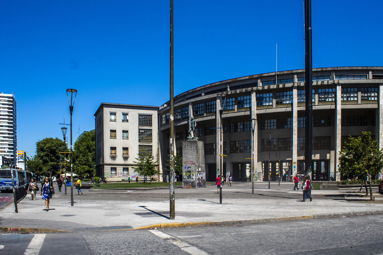 PEOPLE WALKING ON FOOTPATH AGAINST BUILDINGS