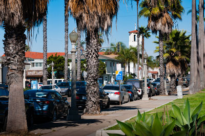 Cars on street in city against clear sky