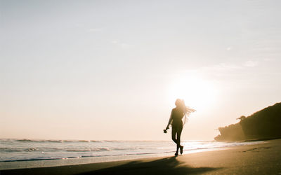 Full length of woman on beach against sky