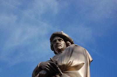 Low angle view of statue against blue sky