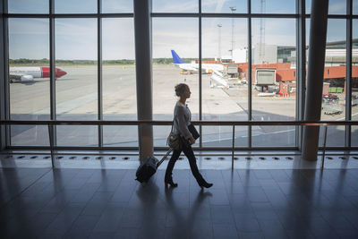 Businesswoman walking with luggage at airport