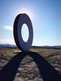 Cross on field against clear blue sky