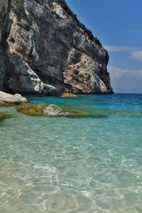 Rock formation in sea against sky