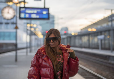 Woman standing at railroad station during winter