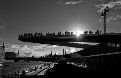 Bridge over river against sky in city