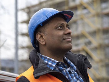 Portrait of young man looking away while standing outdoors