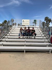 People sitting on staircase against sky