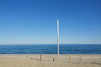 Scenic view of beach against clear blue sky