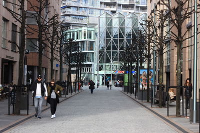 People walking on street amidst buildings in city