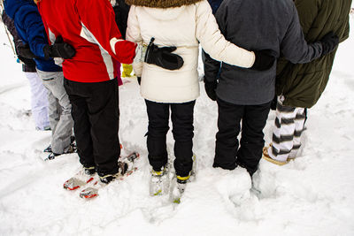 Rear view of people walking in snow