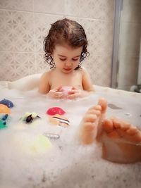 Full length of cute girl in bathtub