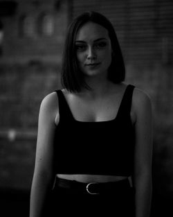 Portrait of beautiful woman standing against blurred background