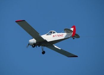 Low angle view of airplane against clear blue sky