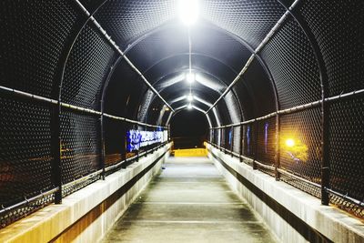 Illuminated tunnel at night