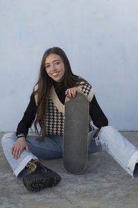 Portrait of smiling young woman sitting outdoors