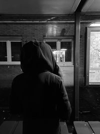 Rear view of man looking through window