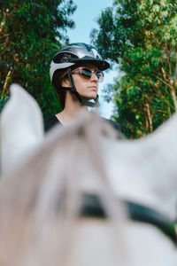 Close-up of young woman with horse against sky