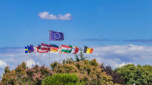 Low angle view of flags against blue sky