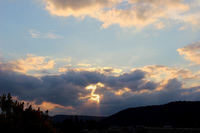 Silhouette of mountain against cloudy sky