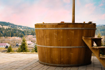 Rustic hot tub against mountain landscape in spring