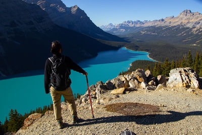 Hiker woman with hiking stick. on a clear sunny autumn day at beautiful peyto lake with turquoise.