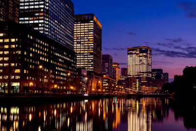 Reflection of illuminated buildings in city at night