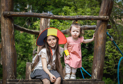 Portrait of two girls in a belgian flag hat in the park.