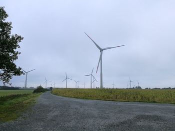 Windmill on road against sky