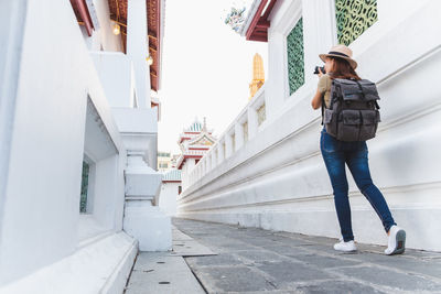 Woman standing on street amidst buildings