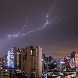 Low angle view of illuminated buildings against sky at night