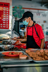 Midsection of woman preparing food at market stall
