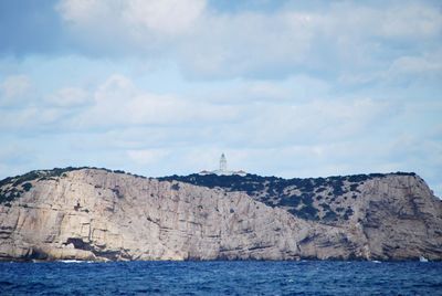 Rock formations by sea against sky