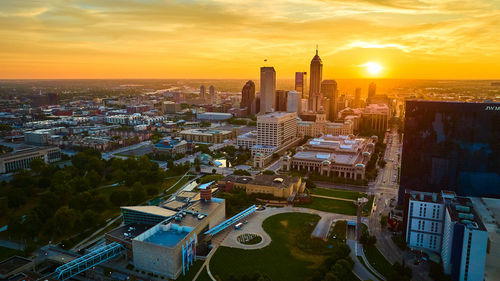 High angle view of buildings in city at sunset